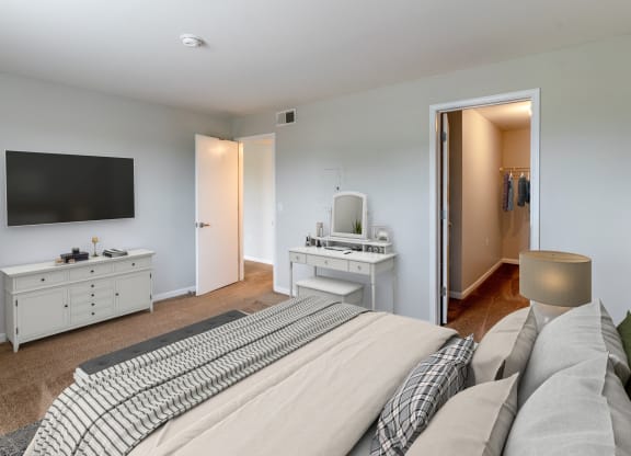 a bedroom with a large bed and a tv on the wall