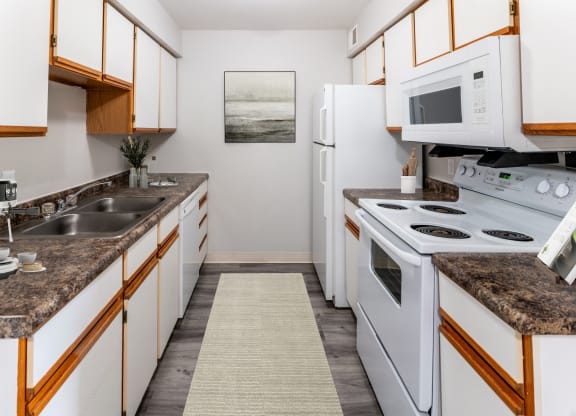 a kitchen with white appliances and granite counter tops