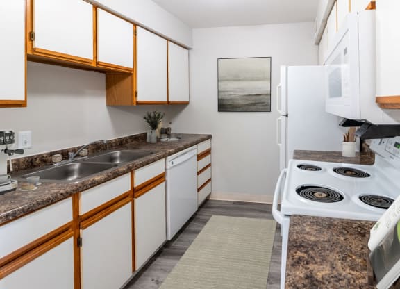 a kitchen with white appliances and granite counter tops