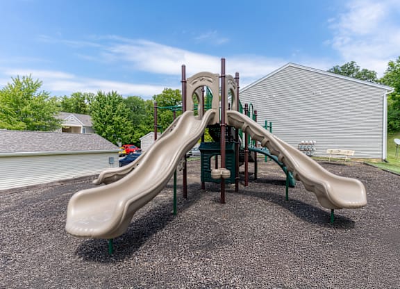 a playground with two slides outside Meadow View Apartments and Townhomes