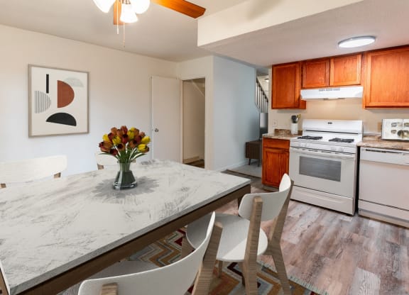 a kitchen with white appliances and a table with chairs