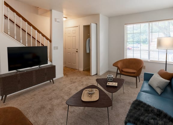 a living room with a blue couch and chairs and a television