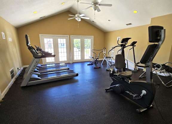 A spacious home gym with treadmills, elliptical machines, and a fan  at Bexley Village, Greenwood