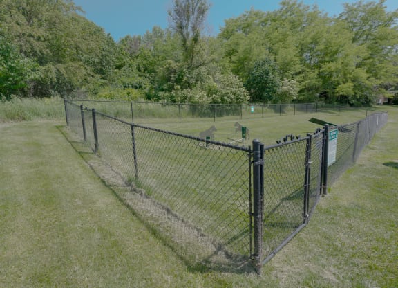 a chain link fence with a fence post and a wire fence in a field