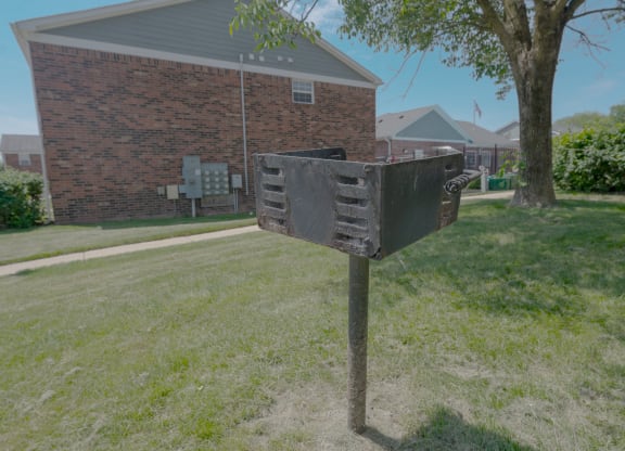 a mailbox in the grass in front of a brick house