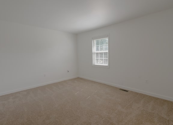 an empty room with carpet and a window