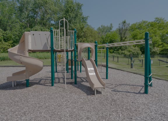 a playground with two slides and a swing set