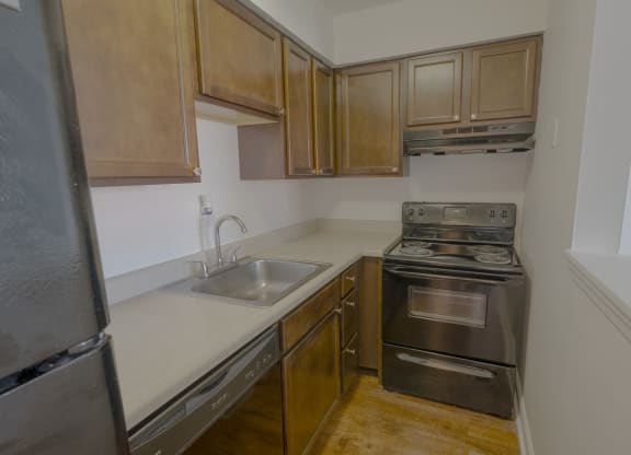 a kitchen with black appliances and wooden cabinets and a sink