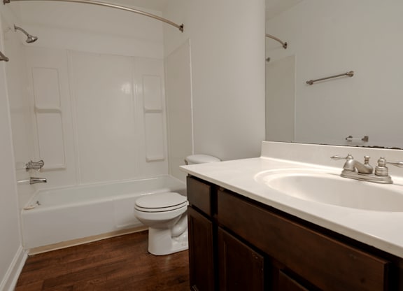 A white toilet sits in a bathroom next to a white sink.