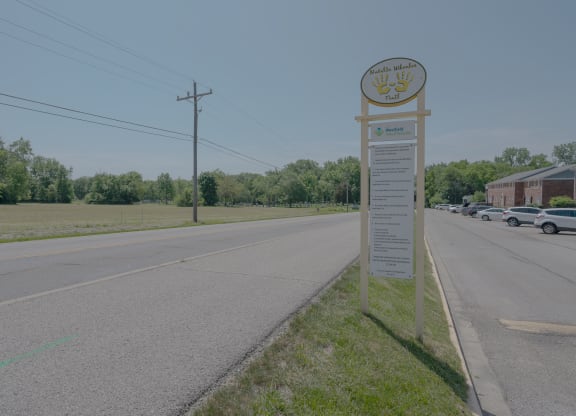 a sign on the side of a road next to a street