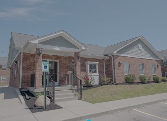 the front of a brick house with a porch and stairs