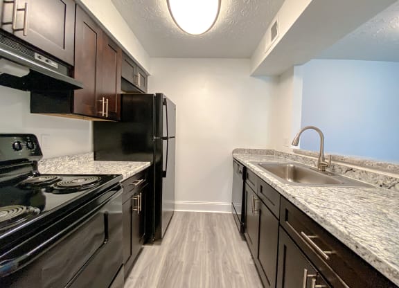 Modern kitchen with faux wood flooring at Camelot East Apartments, Fairfield, OH