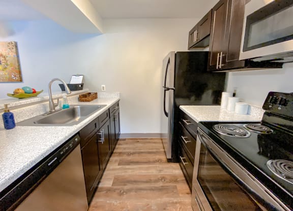 Spacious kitchen with faux wood flooring and stainless steel appliances at Camelot East Apartments, Fairfield, 45014