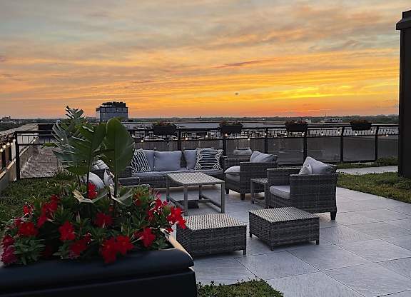 the rooftop terrace at sunset overlooking the ocean and the city skyline