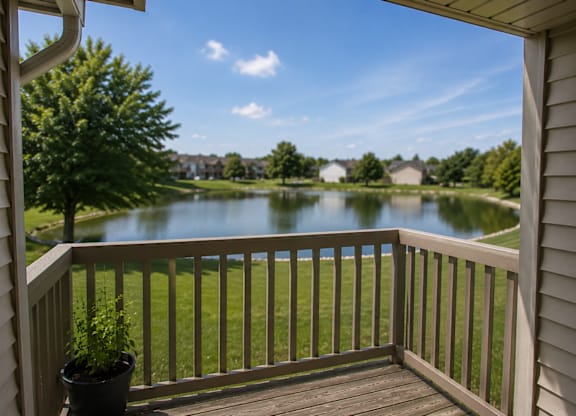 A view from a balcony overlooking a lake and houses.