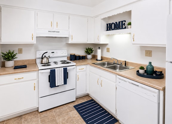 A white kitchen with a sign that says "HOME" on the wall.