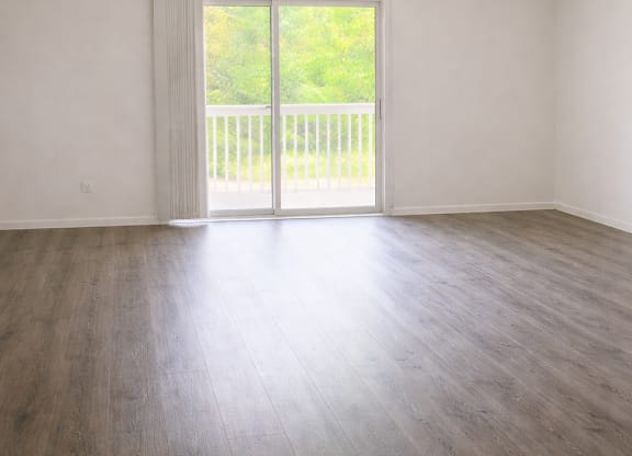 A room with a sliding glass door leading to a balcony.
