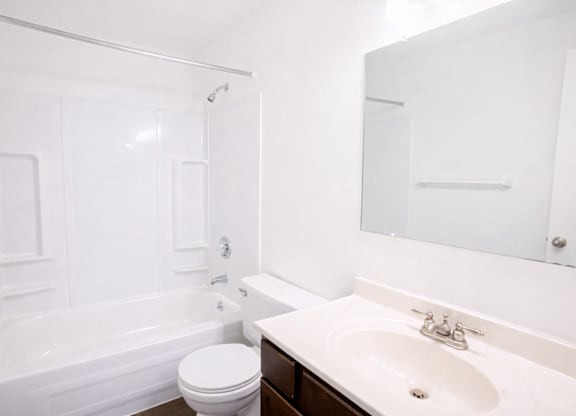 A white bathroom with a toilet, sink, and bathtub.