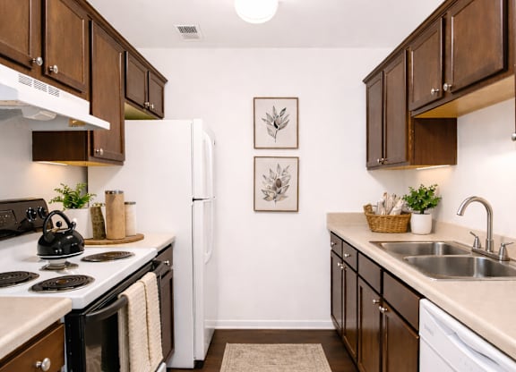 A kitchen with white appliances and wooden cabinets.