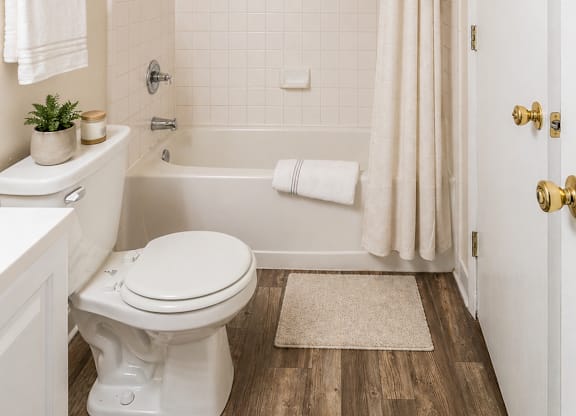 A white toilet sits in a bathroom next to a white sink.