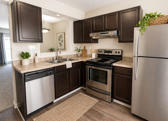 A kitchen with dark brown cabinets and stainless steel appliances.