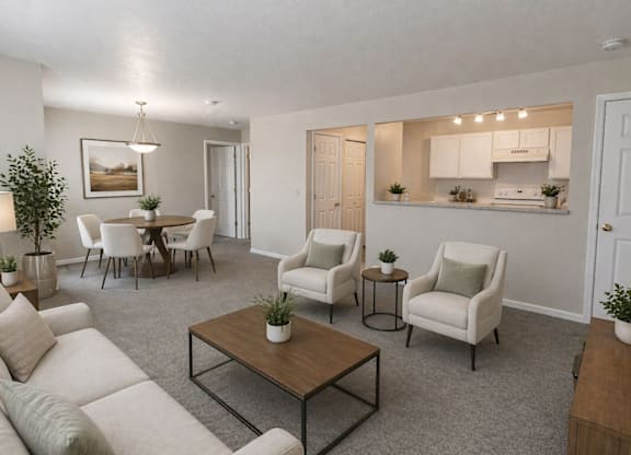 A living room with a white couch, a coffee table, and a dining table with chairs.
