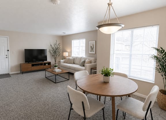 A living room with a grey carpet and a wooden coffee table.