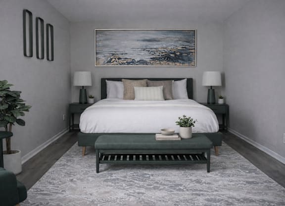 A bedroom with a large bed and a painting on the wall.