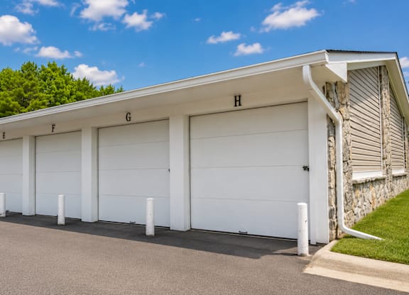 A row of white garage doors are labeled F, G, and H.