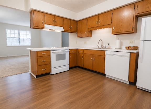A kitchen with wooden cabinets and white appliances.