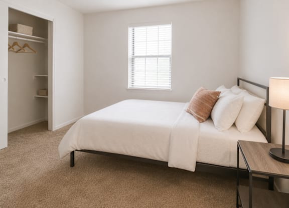 A bedroom with a bed, nightstand, and a wardrobe.