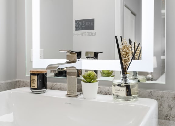 Modern bathroom with Quartz countertops and Bluetooth LED smart mirrors at Park Heights by the Lake Apartments in Chicago, IL 60649