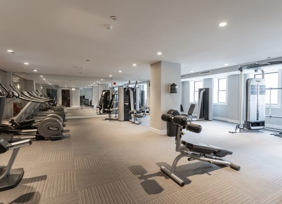 24-hour fitness center equipped with various weights and cardio equipment