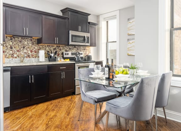 a kitchen with black cabinets and a table and chairs