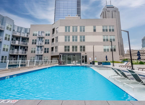 a swimming pool in front of a building in the city