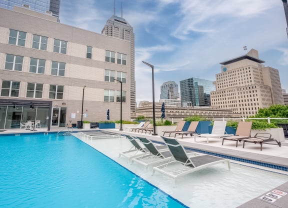 a swimming pool with a city skyline in the background