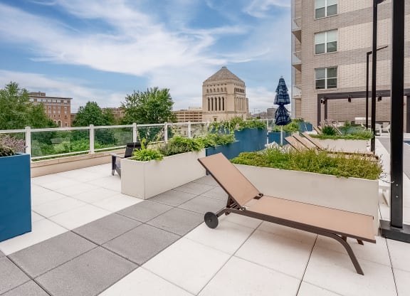 a bench on a roof terrace with a view of the city