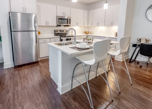 a kitchen with a island and a stainless steel refrigerator