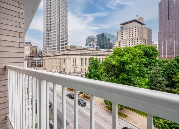the view of the city from a balcony with a white railing