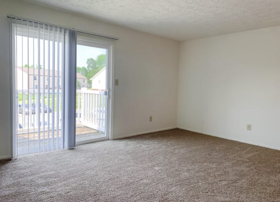 Spacious living room with balcony at Waterstone Place Apartments in Indianapolis, IN 46229