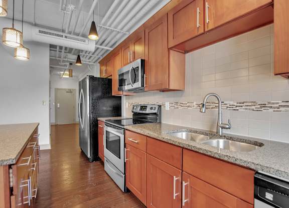 a kitchen with wooden cabinets and a sink and a refrigerator at 100 South Apartments, Buffalo