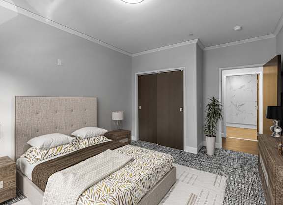 Furnished bedroom with tufted headboard and dark closet doors at Nineteen North Apartments, Buffalo, New York