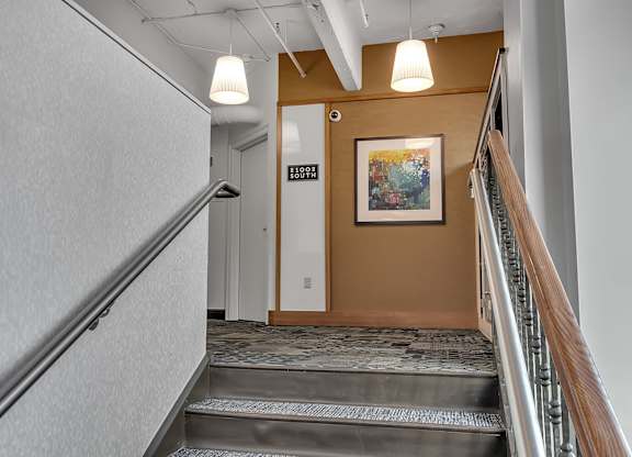 Interior stairwell with carpeted steps and artwork at 100 South Apartments, Buffalo