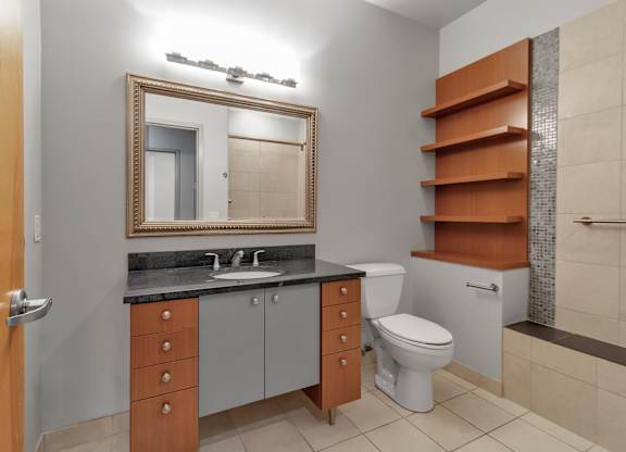 Bathroom with gray and orange vanity cabinets at The Granite Works Apartments, Buffalo