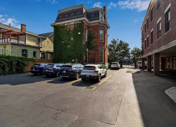 A parking lot with cars parked in front of a red brick building.