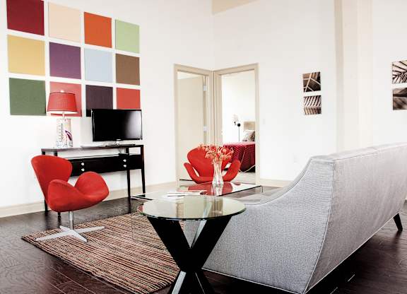 a living room with a couch and a table and a television at 100 South Apartments, Buffalo, 14202