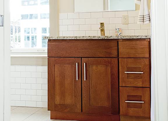 wooden cabinets and a sink and a mirror at 100 South Apartments, New York