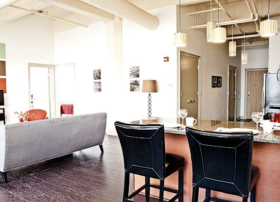 a living room with a couch and a table and chairs at 100 South Apartments, Buffalo, NY 14202