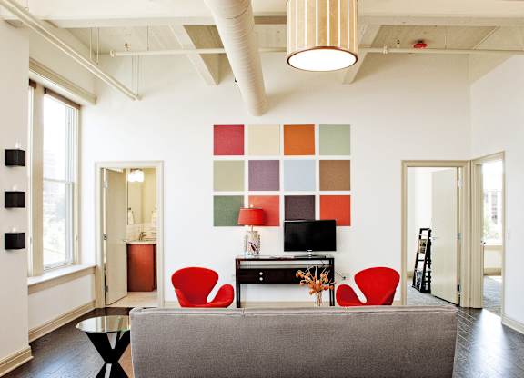 a living room with red chairs and a couch at 100 South Apartments, New York