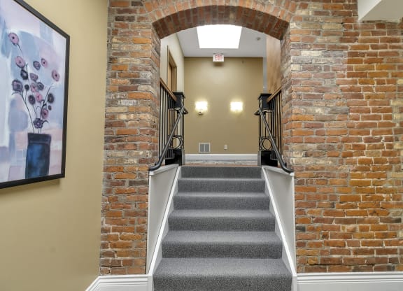 a staircase with brick walls and an arched doorway at The Granite Works Apartments , Buffalo, 14202